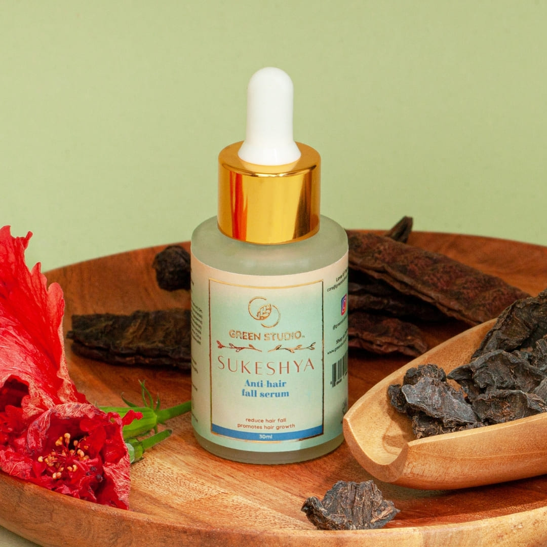 Stylized image of Anti Hair fall Ayurvedic serum from Green Studio Ayurveda with some natural ingredients as props