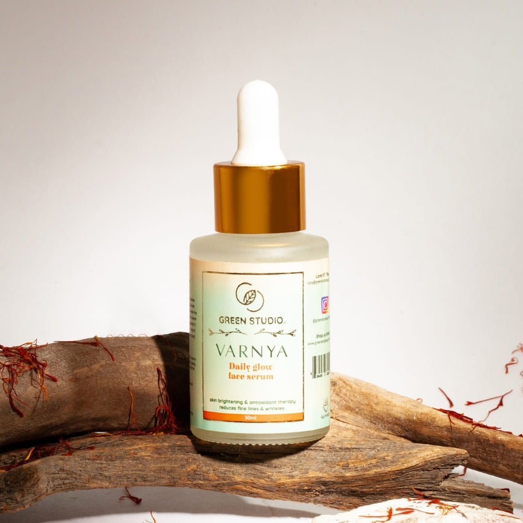 Stylized image of Daily Glow Ayurvedic serum from Green Studio Ayurveda with ingredients as props