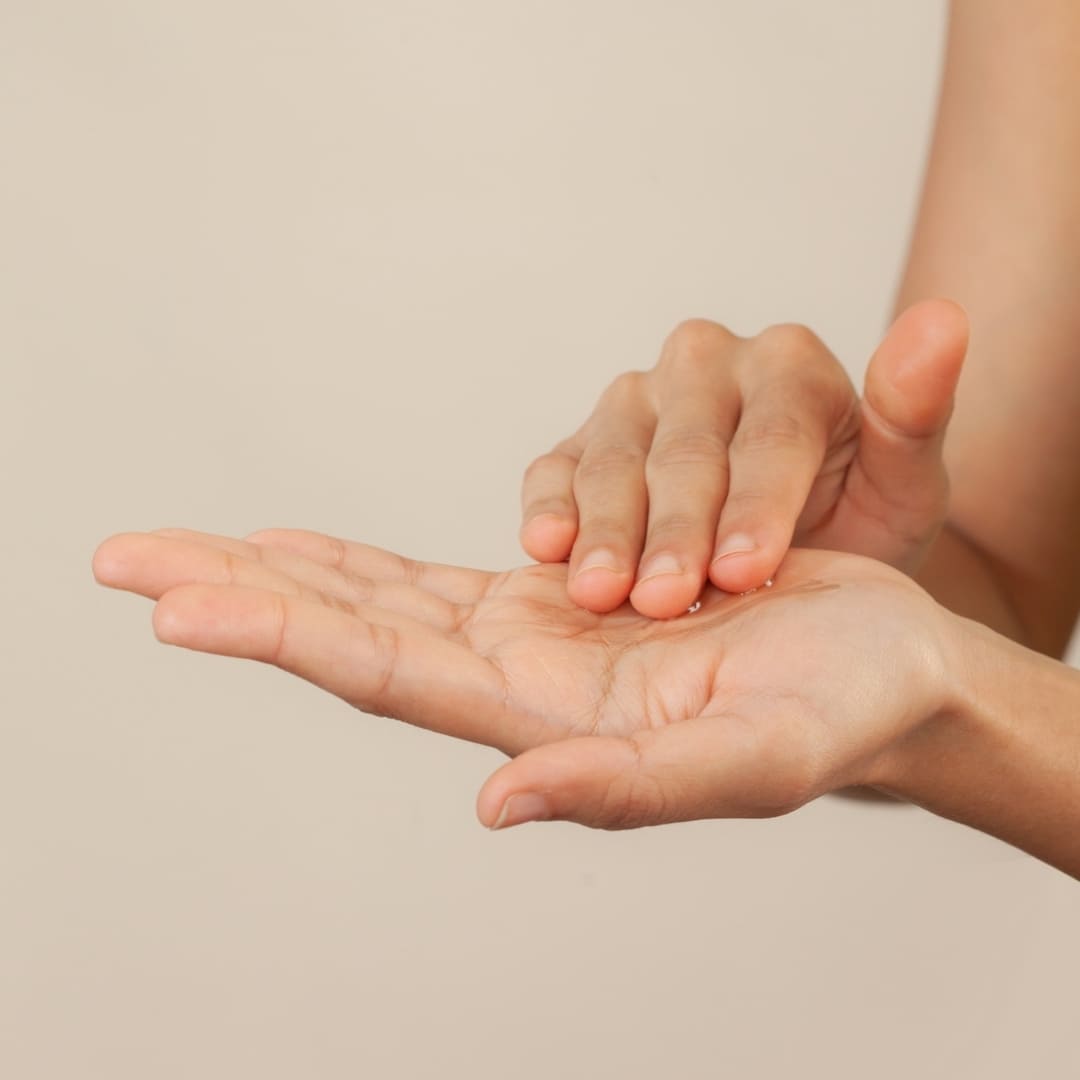 Ayurvedic skincare and hair care serum from Green Studio poured in the hand ready to apply in the skin or hair